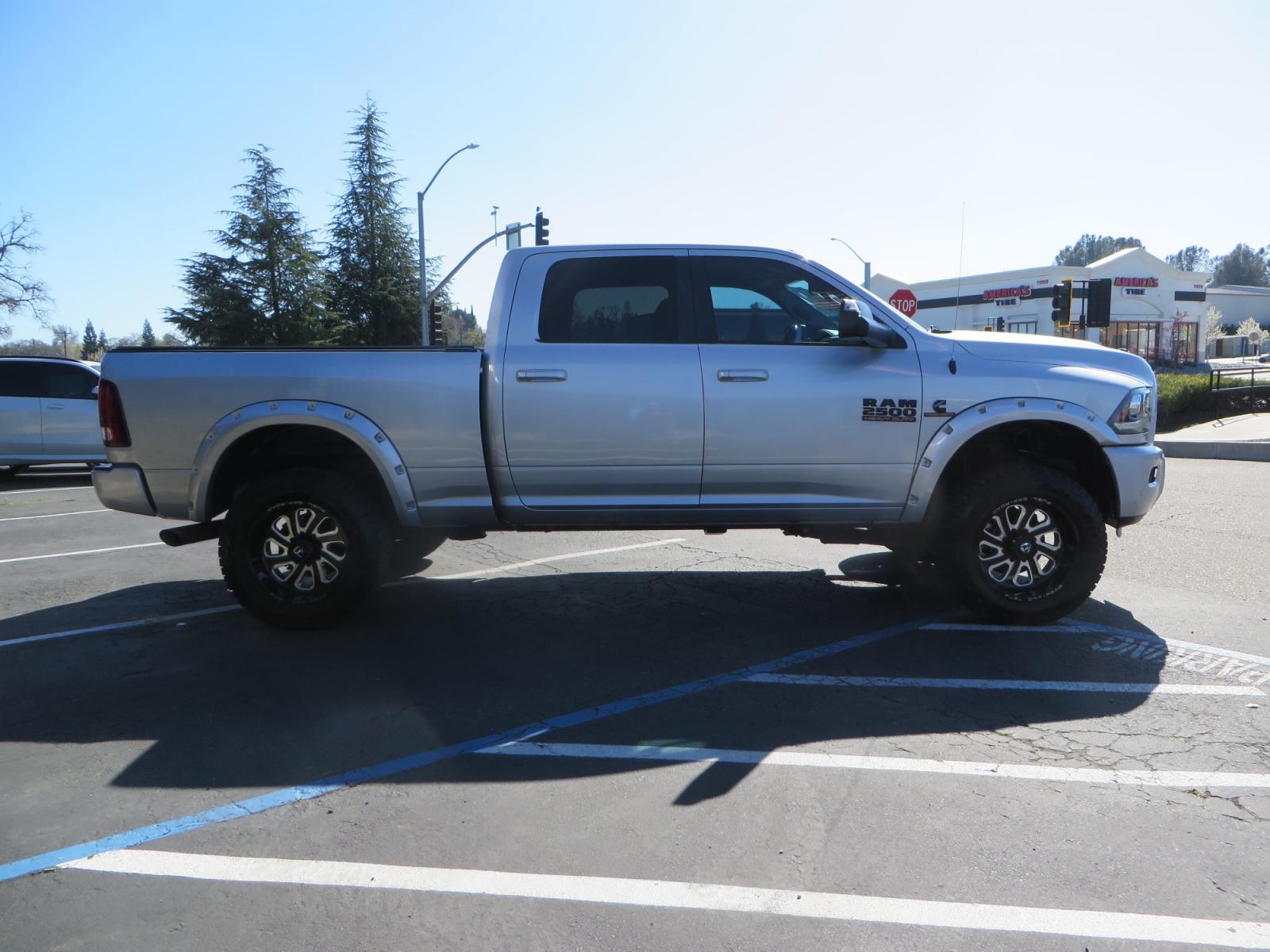 2016 SILVER /BLACK RAM 2500 Laramie Crew Cab SWB 4WD (3C6UR5FL3GG) with an 6.7L L6 OHV 24V TURBO DIESEL engine, 6A transmission, located at 2630 Grass Valley Highway, Auburn, CA, 95603, (530) 508-5100, 38.937893, -121.095482 - Leveled Ram sitting on Fuel Offroad wheels, Falken Wildpeak AT tires, Amp Power steps, Rolling Bed cover, Color matched fender flares, and window tint. - Photo #3